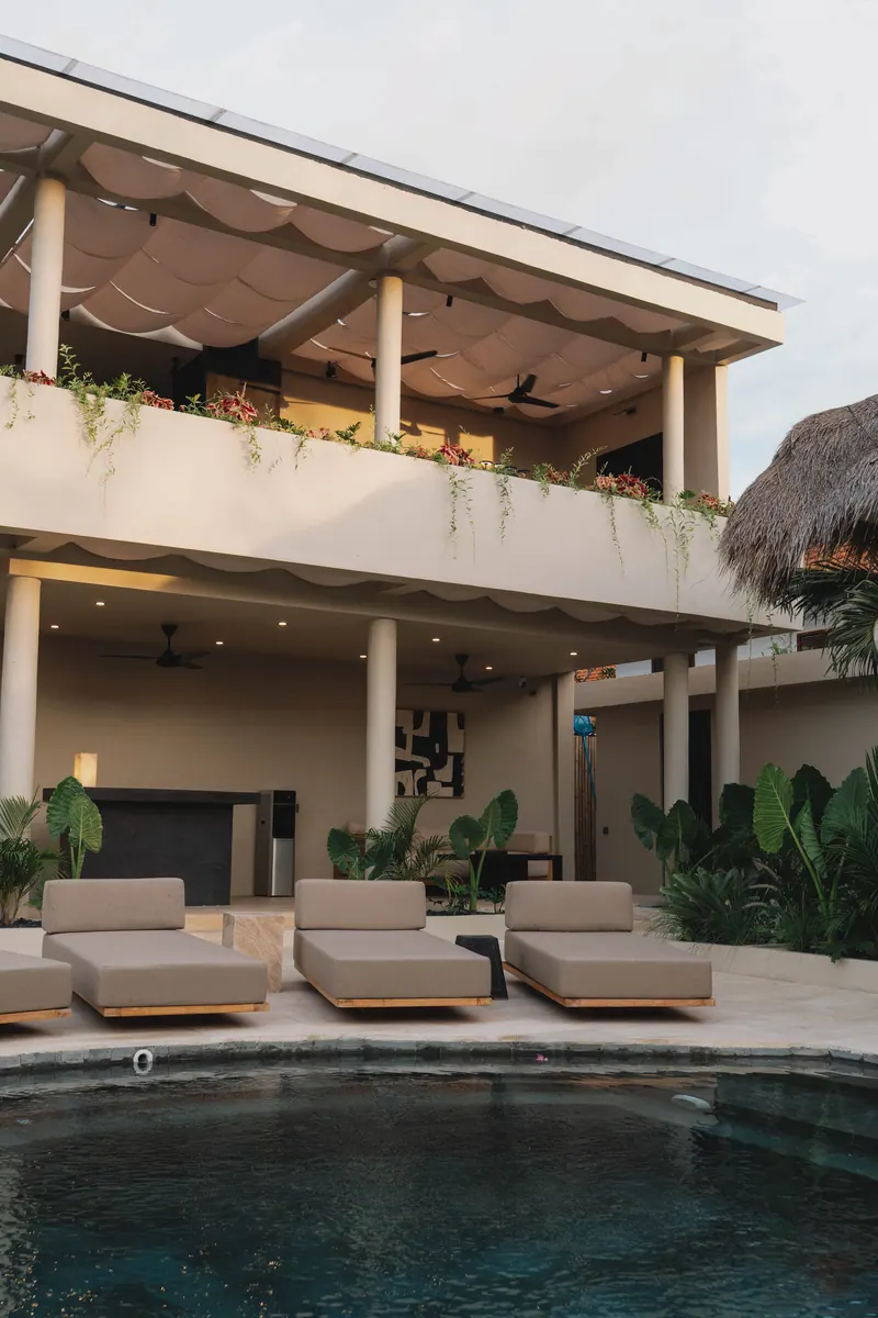 Two-storey building with loungers beside the pool