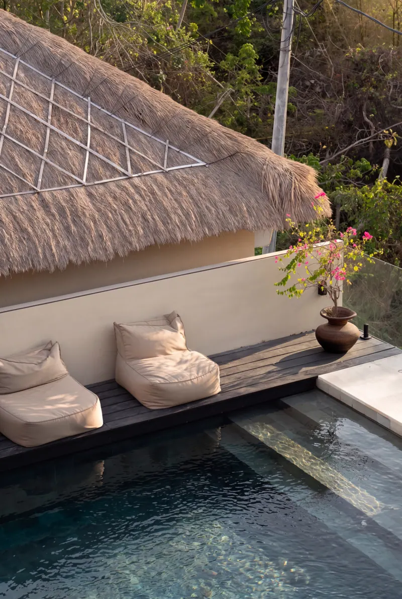 Lounger beside the pool under a thatched roof