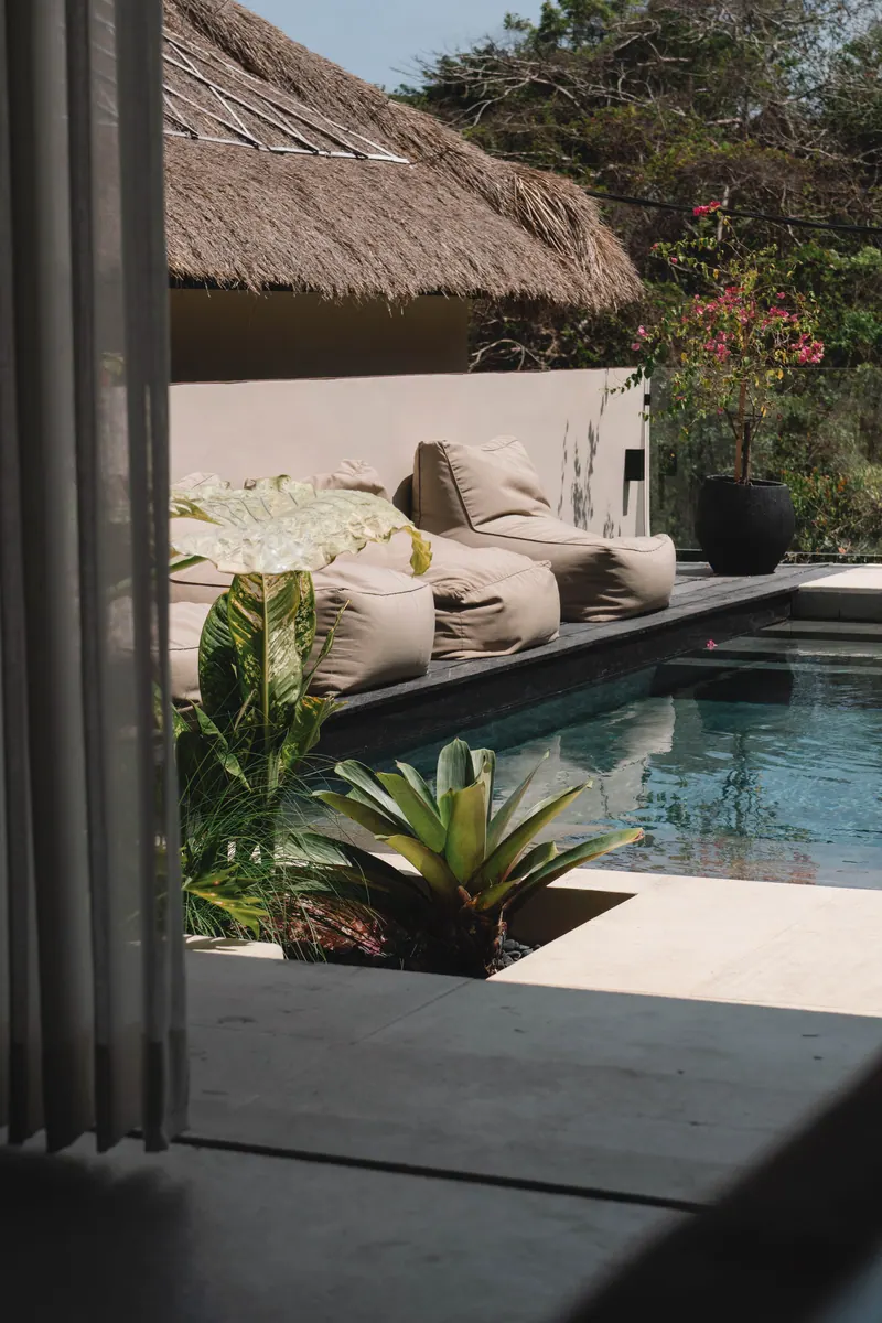 Bean bag loungers by the pool seen through curtains