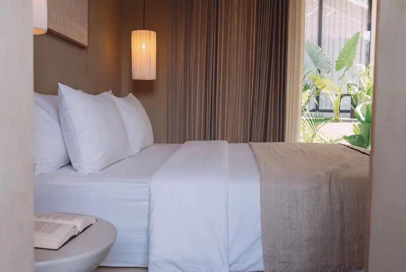 Side view of the bed with curtains and a pendant light